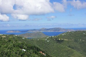 A coastal landscape with hills, a body of water, and scattered buildings.