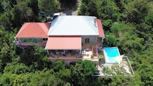 Ein großes Haus mit Schwimmbad, umgeben von dichtem Wald.