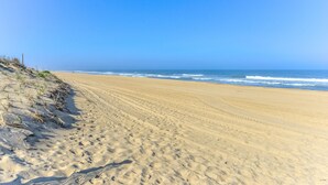 Una platja sorrenca amb empremtes que condueixen al mar.