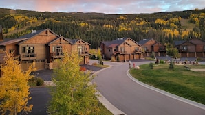 A residential area with wooden houses, a curved driveway, and a forested hillside in the background. - Keystone 4BR Townhome at River Run Base - Prices lowered for open dates! (Keystone)