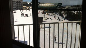 A view of a ski resort from a window, including a ski slope and a building with a sloped roof. - Ski-in/Ski-out, Penthouse Unit w/ Awesome Views, Walk to Village! (Snowshoe)