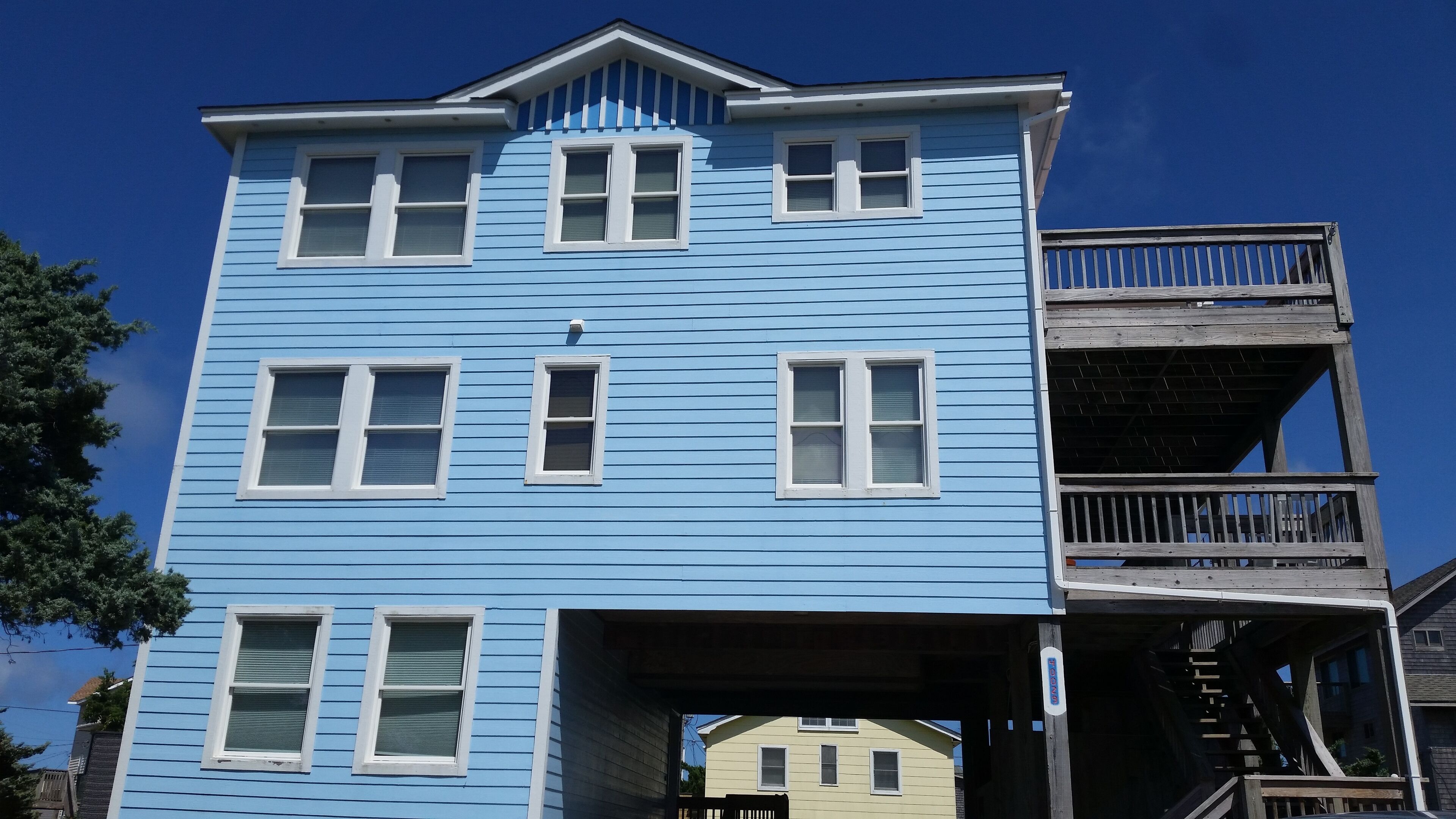 A multi-story building with a blue exterior and white trim.