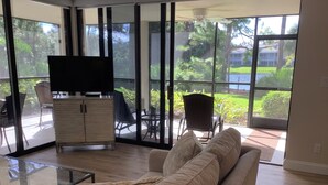 Un vaste salon doté d’une grande porte vitrée donnant accès à un espace patio.