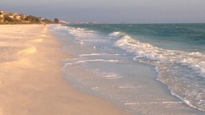 Une plage avec un rivage sablonneux et des vagues douces.