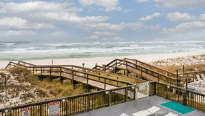 A wooden boardwalk leading to a beach with a sign indicating pool rules. - BEST DEAL ON THE KEY! Updated Gulf Front Condo! Full Ocean Views! (Pensacola)