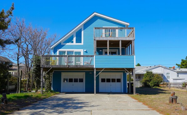 A two-story house with a blue exterior, a balcony on the upper floor, and two garage doors. - Snorkel A Shipwreck...Two Ships Are On The Bottom Just Off The Beach!! (Kill Devil Hills)