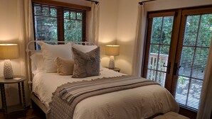 A neatly made bed with a quilted blanket, a decorative pillow, and two bedside lamps. - Spacious home in Carmel: one mile to downtown.  (Carmel-By-The-Sea)
