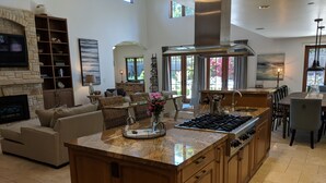 A spacious kitchen with granite countertops, a large island, and a stainless steel range hood. - Spacious home in Carmel: one mile to downtown.  (Carmel-By-The-Sea)