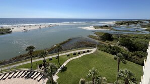Vista sulla costa con spiaggia, un fiume e un parco con sentieri e panchine.