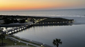 Un resort con piscina, un lungomare e vista sull'oceano al tramonto.