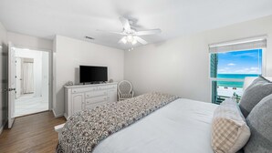A bedroom with a bed, a television, a dresser, and a window with a view of the beach. - From sunrise surf to sunset sips at Beach Life /Gulf Front, Driect Access to Beach from Balcony (Santa Rosa Beach)
