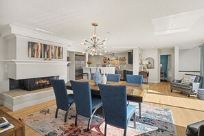 Un salon moderne doté d’une cheminée, d’un coin repas et d’une cuisine.