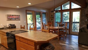 A spacious kitchen with a large island, wooden cabinets, and a stone fireplace. - CREEKSIDE AND MOUNTAIN VIEW! Walk to Main St Frisco, Skiing, Pool, Trails (Frisco)