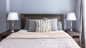A neatly made bed with a wooden headboard, two bedside lamps, and a pillow with the text "let's ski". - Mountain View 4BR Chalet with contactless entry - The Lake at Blue Mountains (Blue Mountains)