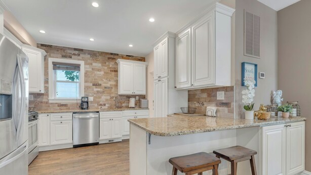 A kitchen with white cabinets, a granite countertop, and two wooden stools. - 22 Grover's Ocean, spacious 5 bedroom home with central AC, 1 block to beach! (Ocean Grove)