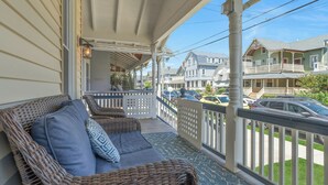 A covered porch with wicker furniture and a view of the street. - 22 Grover's Ocean, spacious 5 bedroom home with central AC, 1 block to beach! (Ocean Grove)