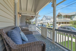 Relax on the covered porch with a sofa and armchairs amidst a patterned floor.