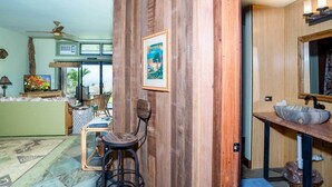 Una stanza con parete in legno, un quadro incorniciato, un angolo bar e vista sull'esterno.