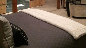 A spa room with a large bed, a massage table, and a glass shower enclosure. - Hilltop 365: Downtown Luxury ~ Stunning Views ~ Hilltop ~ 3 Blocks To Downtown  (Paso Robles)