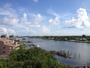 Boats dock at the marina, surrounded by lush greenery and a scenic hillside view.