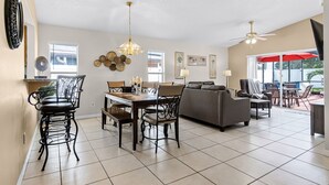 A spacious living area with a dining table, chairs, a sofa, and a ceiling fan. - BUENAVENTURA LAKES (263HS) - 3BR 2BA home with pool in a private setting (Kissimmee)