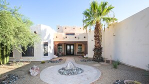 A courtyard with a central water feature, palm trees, and a building with a flat roof and large windows. - Phoenix Scottsdale Golf House. NEW! Private Pickle Ball court. Great location. (Phoenix)