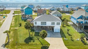 A coastal residential area with houses, a clear sky, and the ocean in the background. - Captain's Quarters - Cabana, Hot Tub, Fire Pit, Fenced Yard! (Freeport)