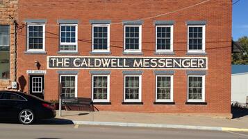 A brick building with a sign reading "The Caldwell Messenger."