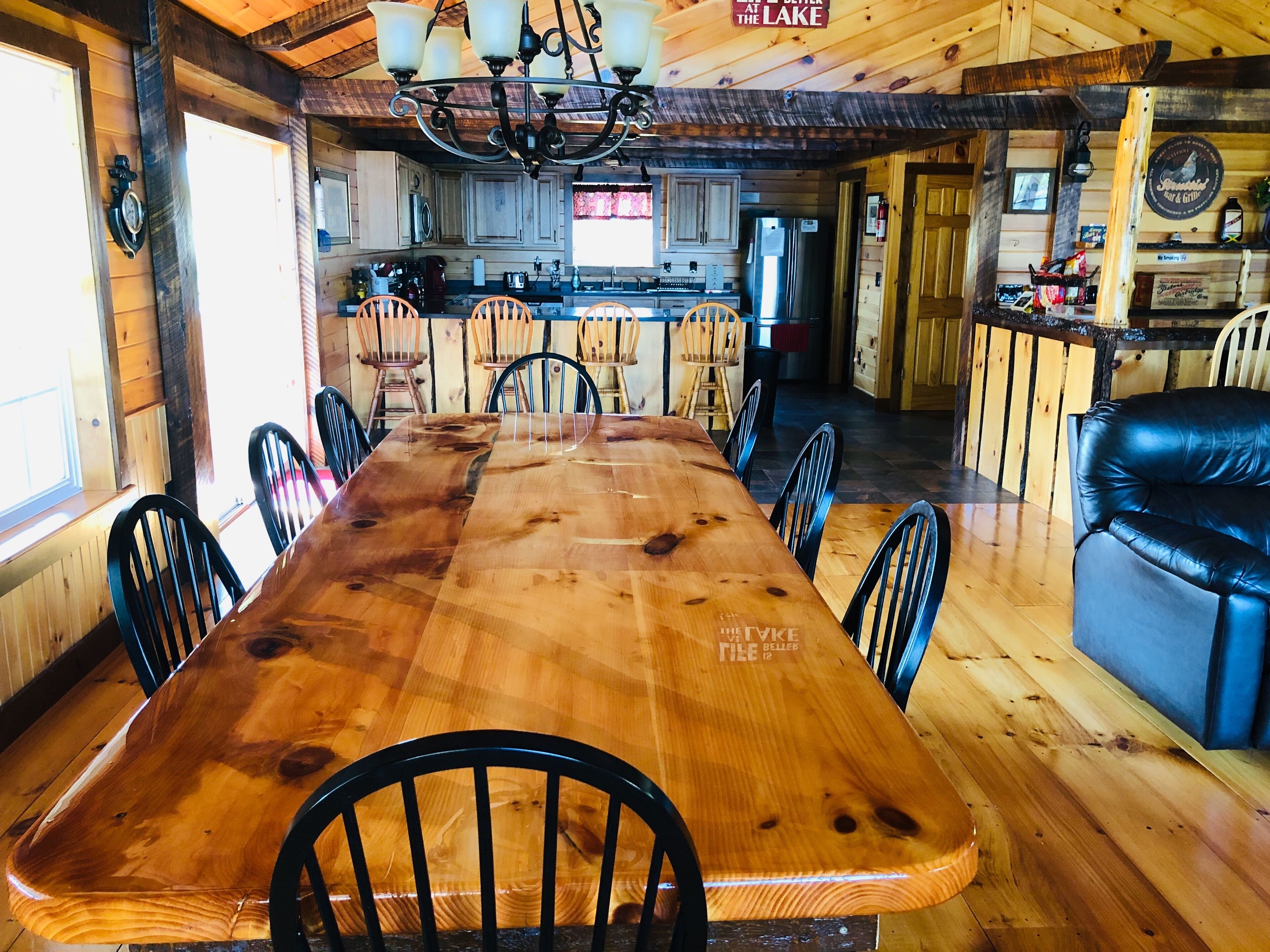 Ein Holztisch mit Stühlen, eine Küchenzeile und eine Bar.