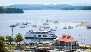 Boats docked in calm waters, surrounded by lush greenery and a scenic boathouse.