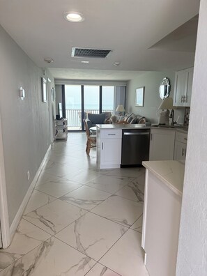 Una cocina moderna con lavavajillas, un fregadero y una zona de comedor con mesa y sillas.