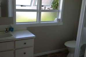 A bathroom with a window, a sink, and a toilet.