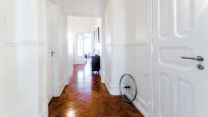 Un couloir avec un plancher en bois et des portes blanches.