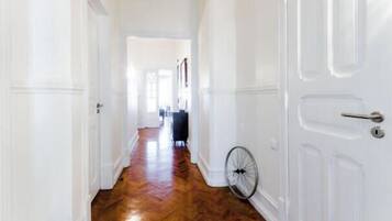 Un couloir avec un plancher en bois et des portes blanches.
