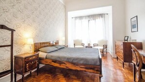 Une chambre à coucher avec un lit en bois, une table de chevet, une commode et une chaise.