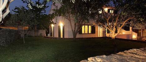 Vista frontal de la propiedad por la tarde o noche