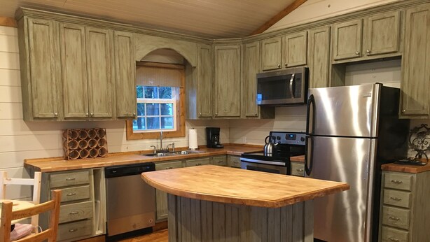 A kitchen with wooden cabinets, a stainless steel refrigerator, a microwave, a stove, and a dishwasher. - Leroy's  farmhouse 7 min to Memphis, ❤️1 pet free 2nd pet considered for fee (Mound City)