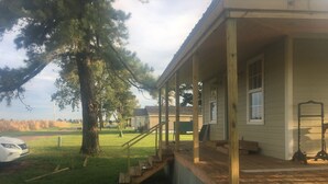 A house with a porch, a staircase leading to the entrance, and a large tree in the yard. - Leroy's  farmhouse 7 min to Memphis, ❤️1 pet free 2nd pet considered for fee (Mound City)