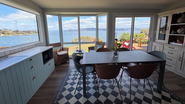 Eine Küche mit einem großen Fenster und Blick auf das Meer und die Hügel.