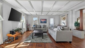 Een woonkamer met een bank, een salontafel, een televisie en een open haard.