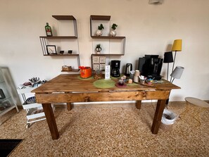A wooden dining table with a coffee maker, a toaster, and various mugs and plates. - Relais il Chiostro Historic Courtyard and Panoramic Terrace near Sorrento (Massa Lubrense)