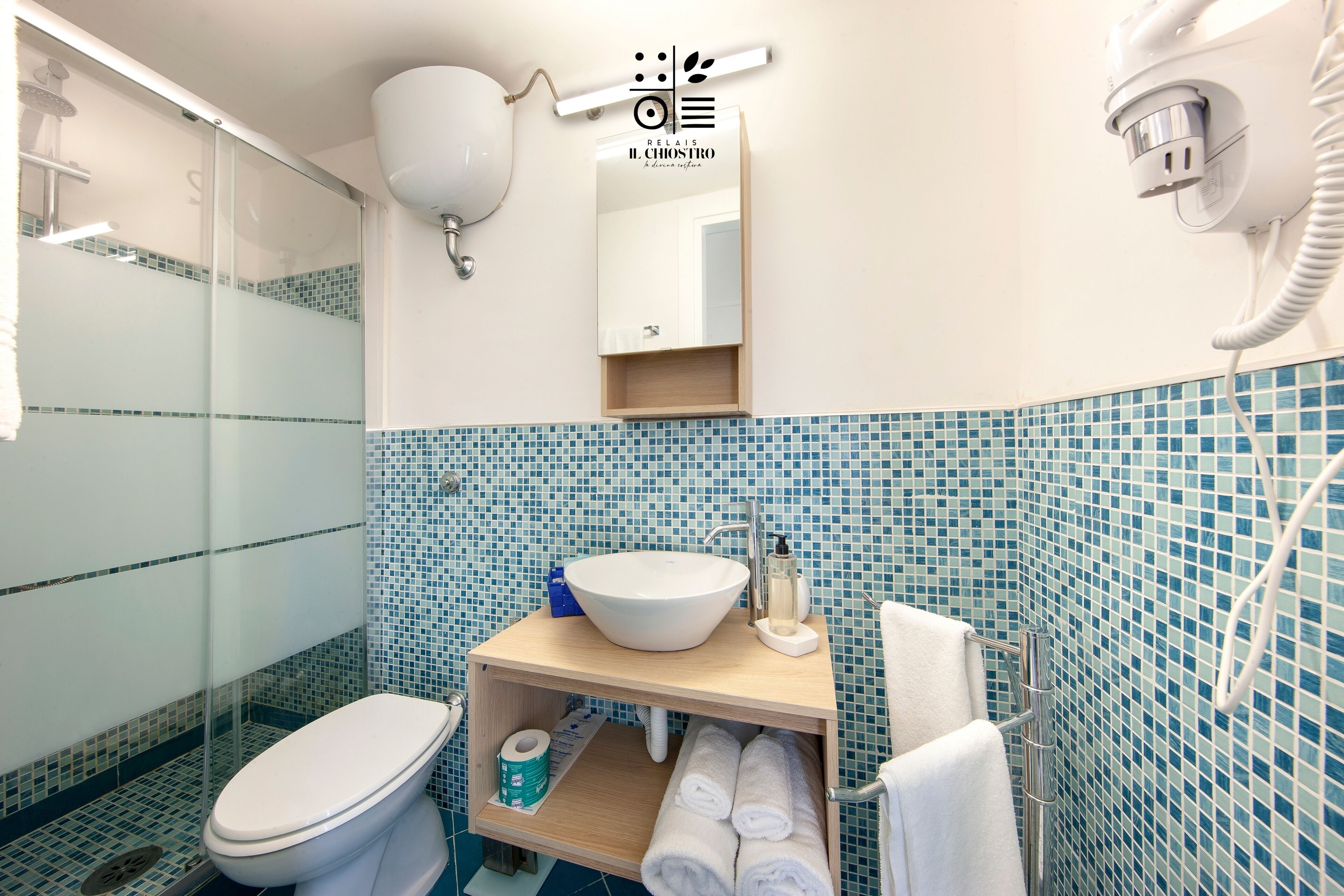 A bathroom with a white sink, a mirror, and a shower.