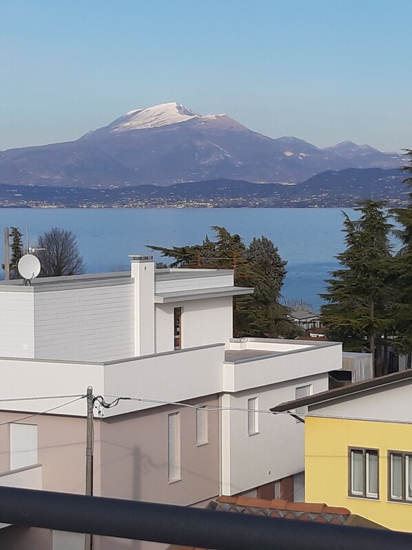 A residential area with modern buildings, a satellite dish, and a view of a mountain.