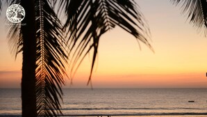 A sunset view at a beach with palm trees in the foreground. - The Village Resort (Ngwe Saung)