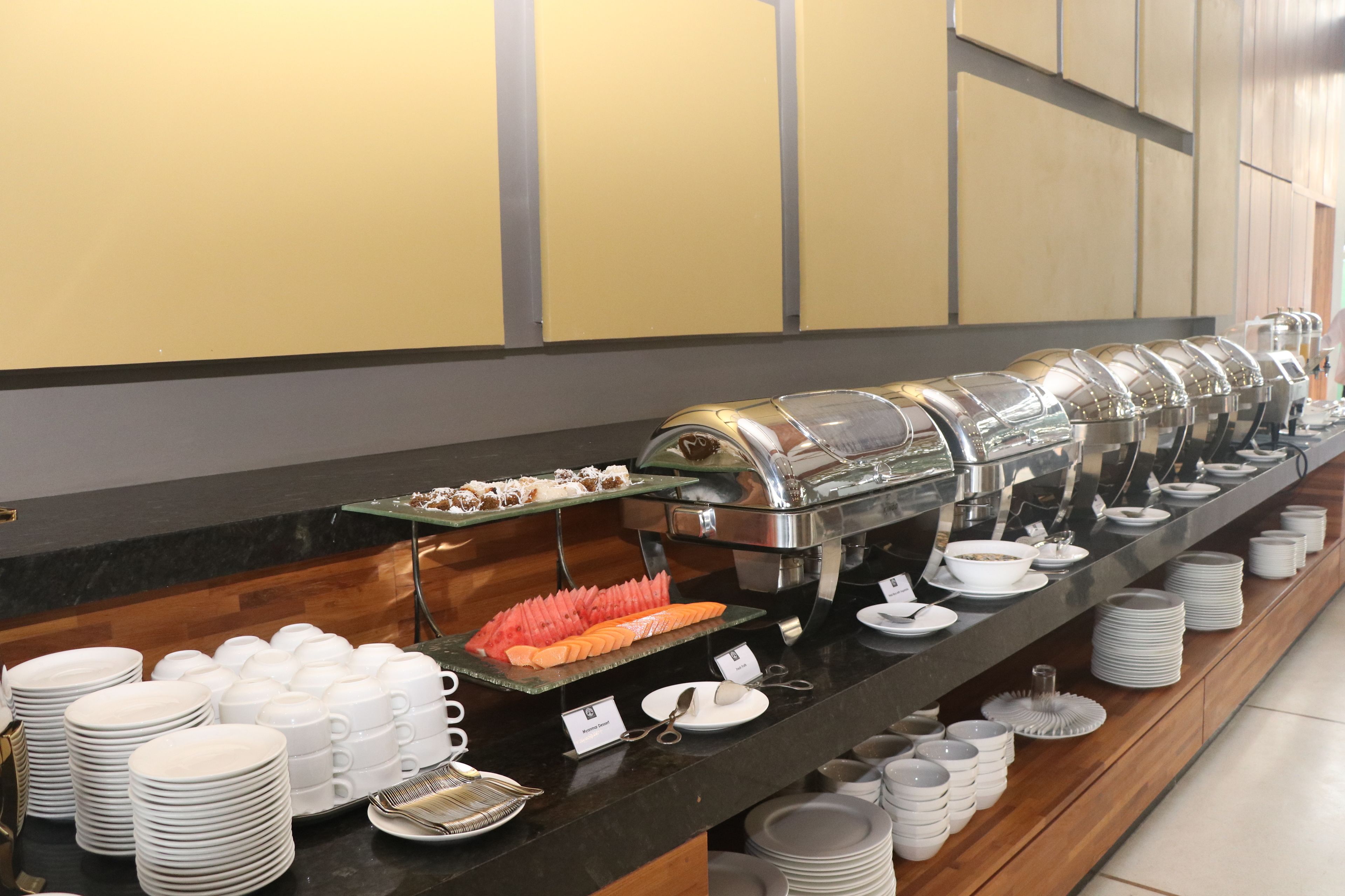 A buffet setup with various food items and utensils.
