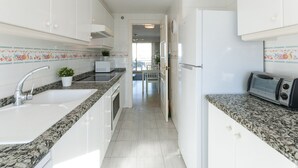 A modern kitchen with white cabinets, granite countertops, a built-in microwave, and a toaster. - Beautiful property with 2 bedrooms. Swimming pool. Wifi - only families (Playa de Gandía)