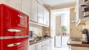A modern kitchen with white cabinets, a red refrigerator, a microwave, and a sink. - Live the most authentic Seville TRIANA ↑ Qualities (Sevilla)