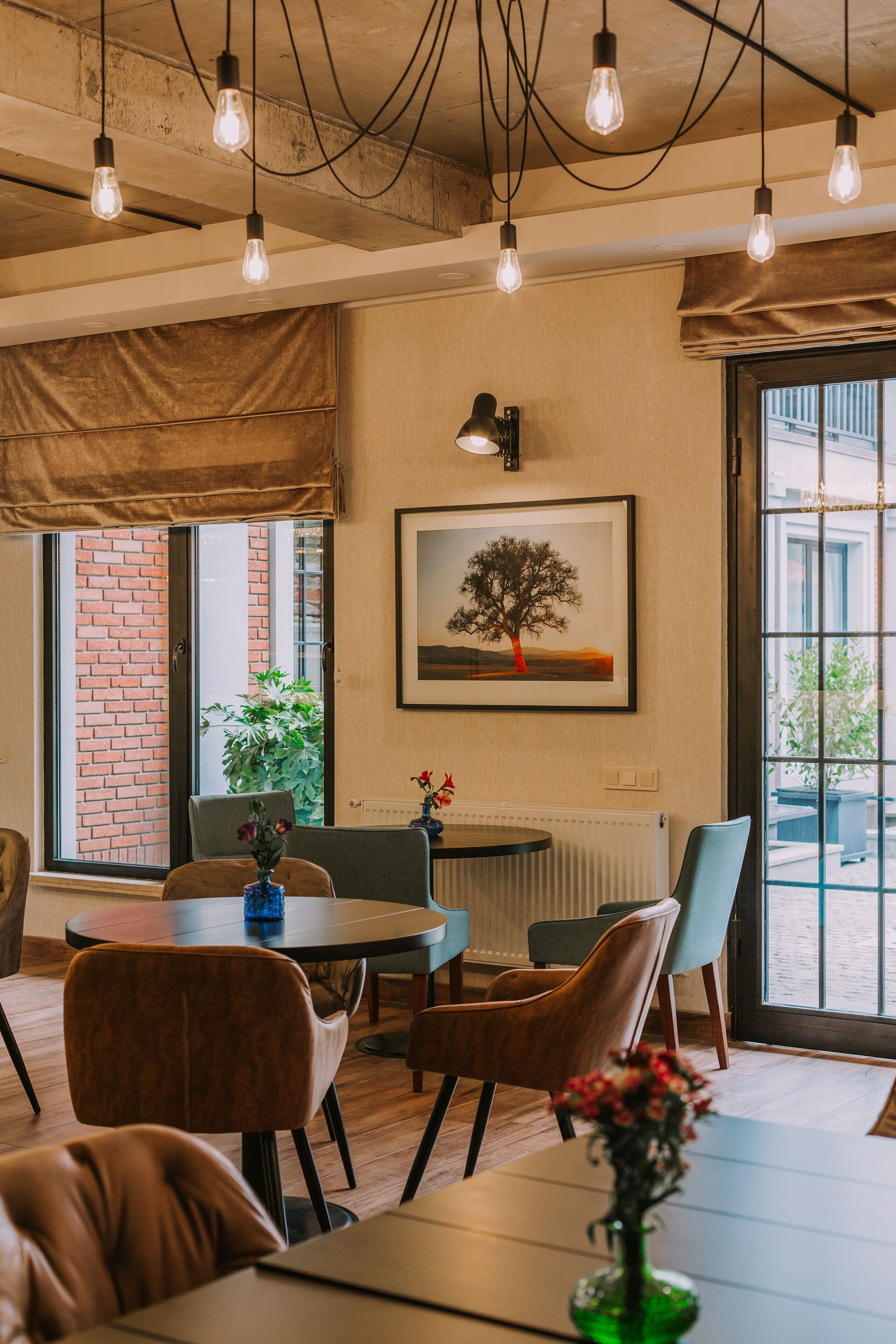 Un comedor moderno con paredes de ladrillo visto, un ventanal con vistas y una mesa con sillas.