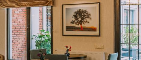 Un comedor moderno con paredes de ladrillo visto, un ventanal con vistas y una mesa con sillas.
