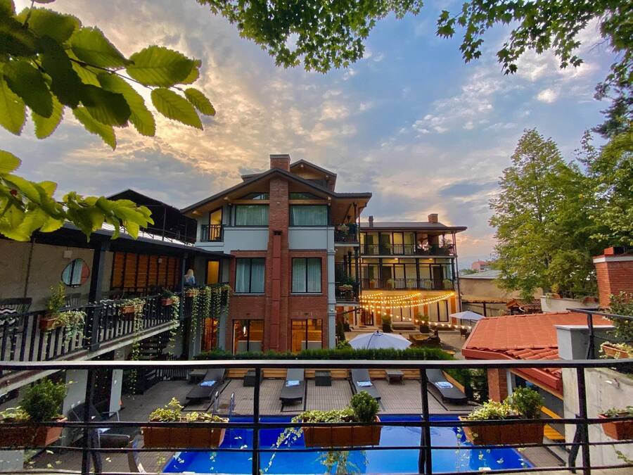 A modern building with a pool area, featuring a large outdoor seating area and a well-maintained garden.
